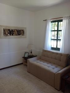 a living room with a couch and a window at Castillo del Lago Carlos Paz - Solo Familiar in Villa Carlos Paz