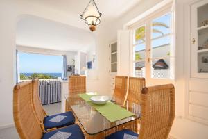 a dining room with a table and chairs and a window at La Casa Del Puerto, Puerto Calero in Puerto Calero