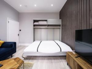 a bedroom with a bed and a flat screen tv at Modern apartment near Wembley Stadium in London