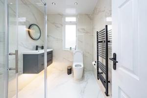 a bathroom with a toilet and a sink and a mirror at Modern apartment near Wembley Stadium in London