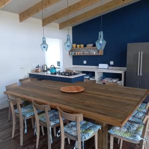 una cucina con un grande tavolo in legno e sedie di Let the good times roll-with inverter and wifi a Cape St Francis