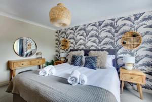 a bedroom with a bed with towels on it at Belle Vue Cottage in Downham Market
