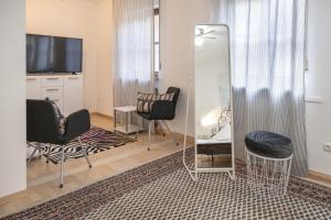 a living room with two chairs and a mirror at Hotel Am Dom in Bamberg