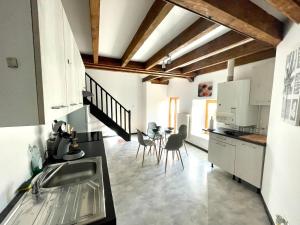 een keuken met een wastafel en een tafel met stoelen bij Appartement La Tour in Vesoul