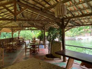 a restaurant with tables and chairs and a view of the water at Pousada e Camping Lumiar in Lençóis