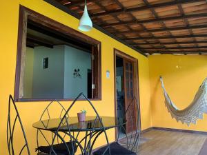 einen Glastisch in einem Zimmer mit gelber Wand in der Unterkunft Pousada e Camping Lumiar in Lençóis