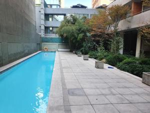 a swimming pool in a courtyard with a building at Departamento amplio en Suite, Costanera Center in Santiago