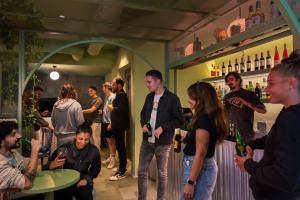 un grupo de personas de pie alrededor de un bar en COEO Pod Hostel - Part of COEO Experience, en Málaga