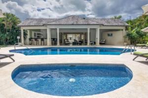 a swimming pool in a yard with a house at Battaleys Mews lovely secure villa 5 minutes from Mullins beach in Saint Peter