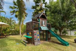 a play house with a slide and a playground at Battaleys Mews lovely secure villa 5 minutes from Mullins beach in Saint Peter