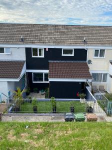 a house with a black garage in a yard at Southway Double Room near Derriford in Plymouth