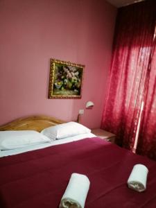 コルトーナにあるIl Centraleのピンクの壁のベッドルーム1室(大型ベッド1台付)
