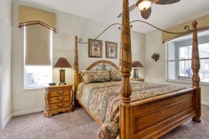 een slaapkamer met een houten bed en een raam bij Mickeys Sunspot - 6 bed Emerald Island Resort pool home in Kissimmee