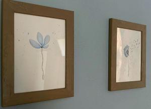 zwei gerahmte Bilder einer Blume an einer Wand in der Unterkunft Agriturismo Agagin in Agaggio Inferiore