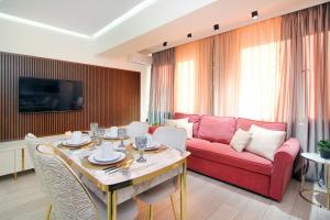 - un salon avec une table et un canapé rouge dans l'établissement Прекрасные апартаменты для путешествующих семей, à Almaty