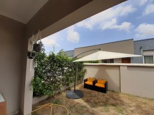 a patio with an umbrella and two chairs under it at Lovely 2-Bed House in Accra East legon hills in Accra