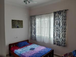 Schlafzimmer mit einem Bett und einem Fenster in der Unterkunft Lovely 2-Bed House in Accra East legon hills in Accra