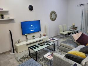 a living room with a couch and a tv at Lovely 2-Bed House in Accra East legon hills in Accra