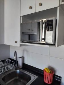 a kitchen with a sink and a microwave at Departamento central Viña del Mar in Viña del Mar