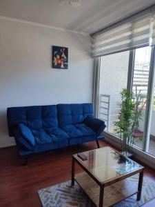 uma sala de estar com um sofá azul e uma mesa em Departamento central Viña del Mar em Viña del Mar