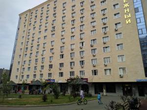 un grand bâtiment bien exposé avec un panneau. dans l'établissement Прекрасные апартаменты для путешествующих семей, à Almaty