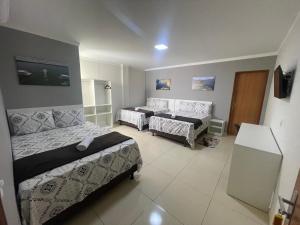 卡寧德聖弗朗西斯科的住宿－POUSADA CECILIA，一间带两张床和一张沙发的客厅