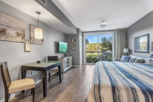 a bedroom with a bed and a desk and a tv at Sandestin Resort Bahia-Elation by Tufan in Destin