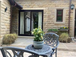 a patio with two chairs and a table with a potted plant at Beautiful 1 bedroom holiday home in Lancaster in Lancaster +8 photos