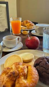 - une table avec des assiettes de produits pour le petit-déjeuner et du jus d'orange dans l'établissement Agriturismo Agagin, à Agaggio Inferiore