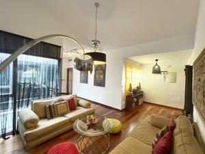 a living room with a couch and a table at Ático en Plaza de la Constitución 3 bedrooms in Málaga