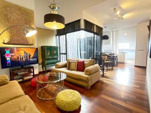 a living room with a couch and a tv and a table at Ático en Plaza de la Constitución 3 bedrooms in Málaga