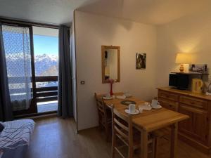 a room with a dining table and a room with a window at Appartement Puy-Saint-Vincent, 1 pièce, 4 personnes - FR-1-330G-11 in Puy-Saint-Vincent