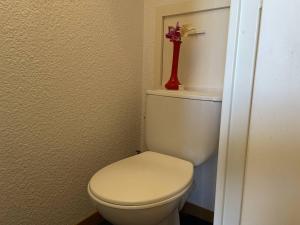 a bathroom with a toilet with a red vase on top of it at Appartement Puy-Saint-Vincent, 1 pièce, 4 personnes - FR-1-330G-11 in Puy-Saint-Vincent