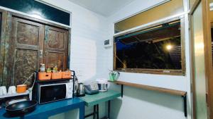 a kitchen with a counter with a microwave and a window at Baan Laanta@Lanta in Ko Lanta