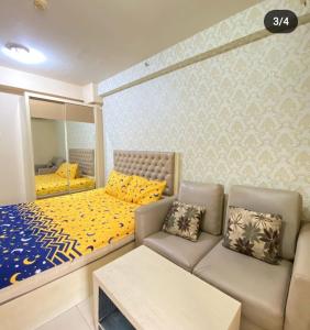 - une chambre avec un lit, un canapé et un miroir dans l'établissement Sewa Apartemen Kalibata City by The Best, à Jakarta