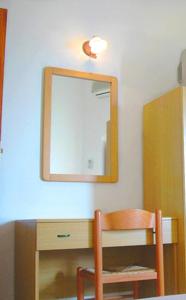 a mirror on a wall with a table and a chair at Ludovica Apartment in Positano