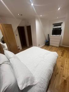ein Schlafzimmer mit einem großen Bett mit weißer Bettwäsche in der Unterkunft Hampden Rd N8,Studio Flat in London