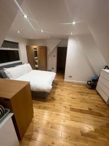 a bedroom with a bed and a wooden floor at Hampden Rd N8,Studio Flat in London