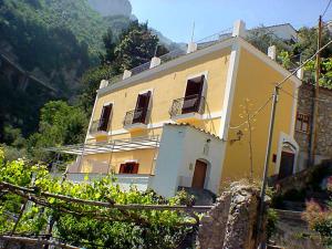 a yellow house on top of a mountain at Ludovica Room in Positano