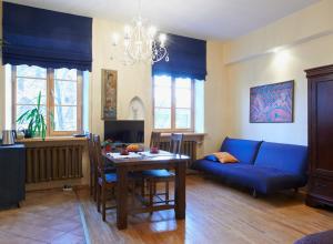 salon ze stołem i niebieską kanapą w obiekcie Regina House- sv. Mikalojaus 13 w Wilnie