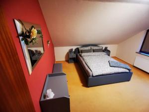 a bedroom with a bed and a red wall at Haus Kalli in Walkenried