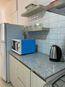 a microwave sitting on a counter in a kitchen at Rivadavia Apart in Mar del Plata