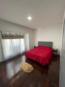 a bedroom with a red bed with a red blanket at Rivadavia Apart in Mar del Plata
