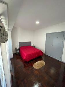 a bedroom with a red bed and a wooden floor at Rivadavia Apart in Mar del Plata