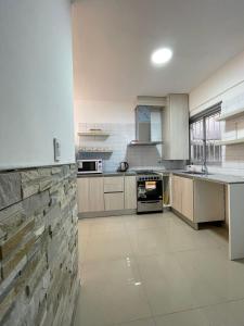 a large kitchen with a stone wall at Rivadavia Apart in Mar del Plata