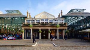 倫敦的住宿－［FITZROVIA-COVENT GARDEN］CENTRAL LONDON APARTMENT，一座大型建筑,前面的人在步行