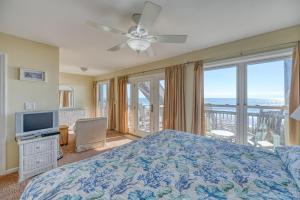 a bedroom with a bed and a television and a balcony at Paradiso a Mare in North Topsail Beach