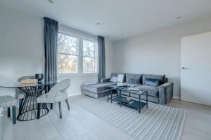 a living room with a couch and a table at Modern and Luxurious 2 Bedroom Flat - Barons Court in London