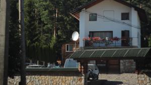 a white house with a balcony and a satellite at Petrovmotopunkt in Yaremche