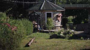 une petite maison dans une cour avec un jardin dans l'établissement Petrovmotopunkt, à Yaremtche